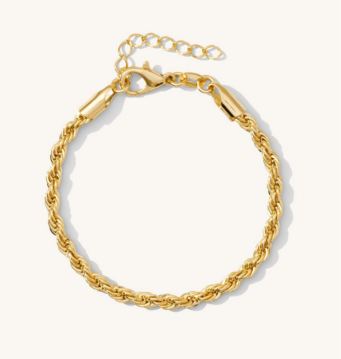 Close up of a gold bracelet on a white background