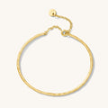 Close up of a gold bangle on a white background
