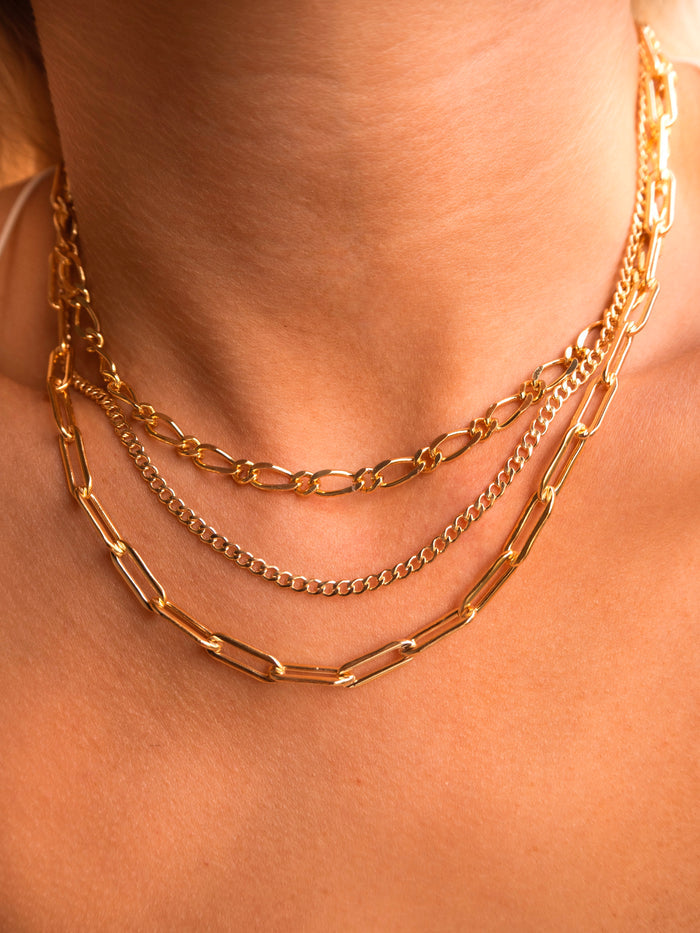Gold Harper curb chain necklace styled with layered gold jewelry