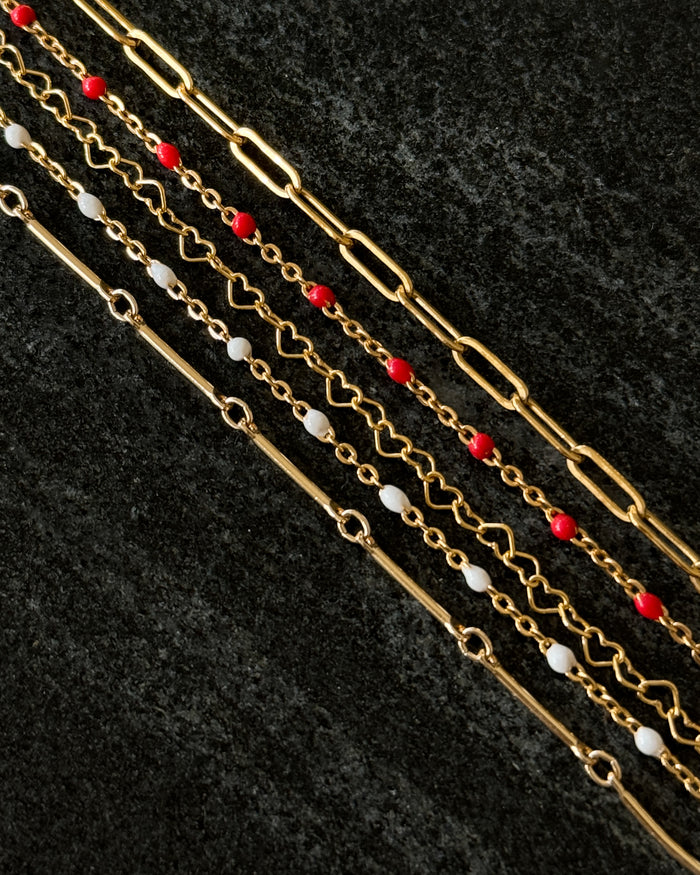 Close up of assorted chain bracelets on a dark background