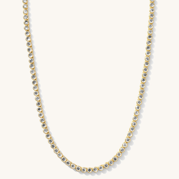 Close up of the gold Heirloom bezel tennis necklace on a white background