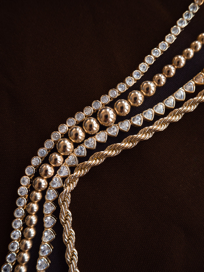 Campaign shot of a model wearing the gold Heirloom bezel tennis necklace