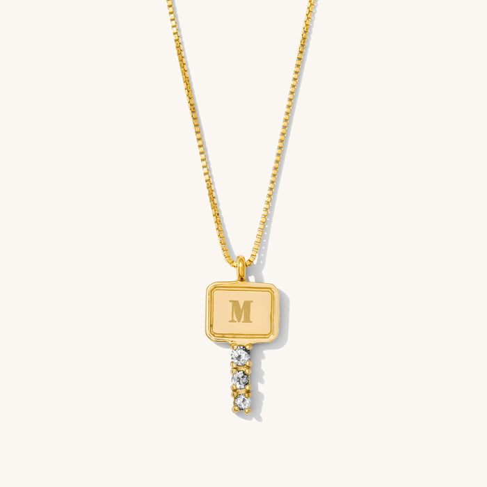 Close up of the gold Heirloom Key necklace on a white background