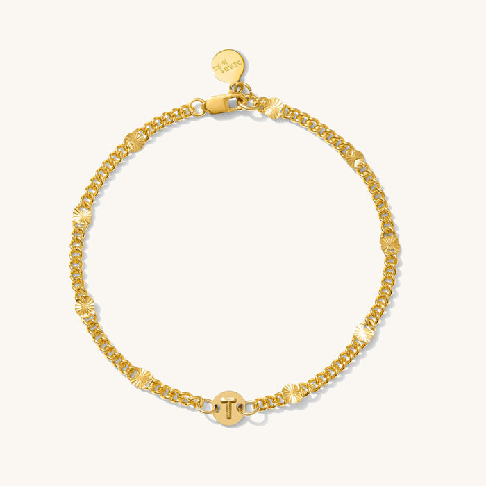Close up of a gold bracelet on a white background