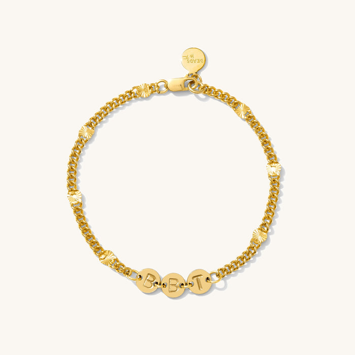Close up of a gold bracelet on a white background