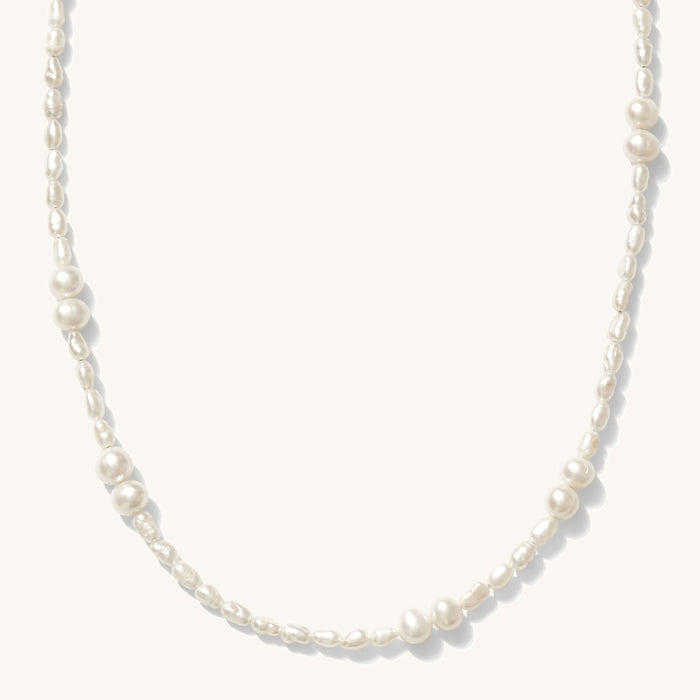 Close up of the gold and freshwater pearl Isla necklace on a white background