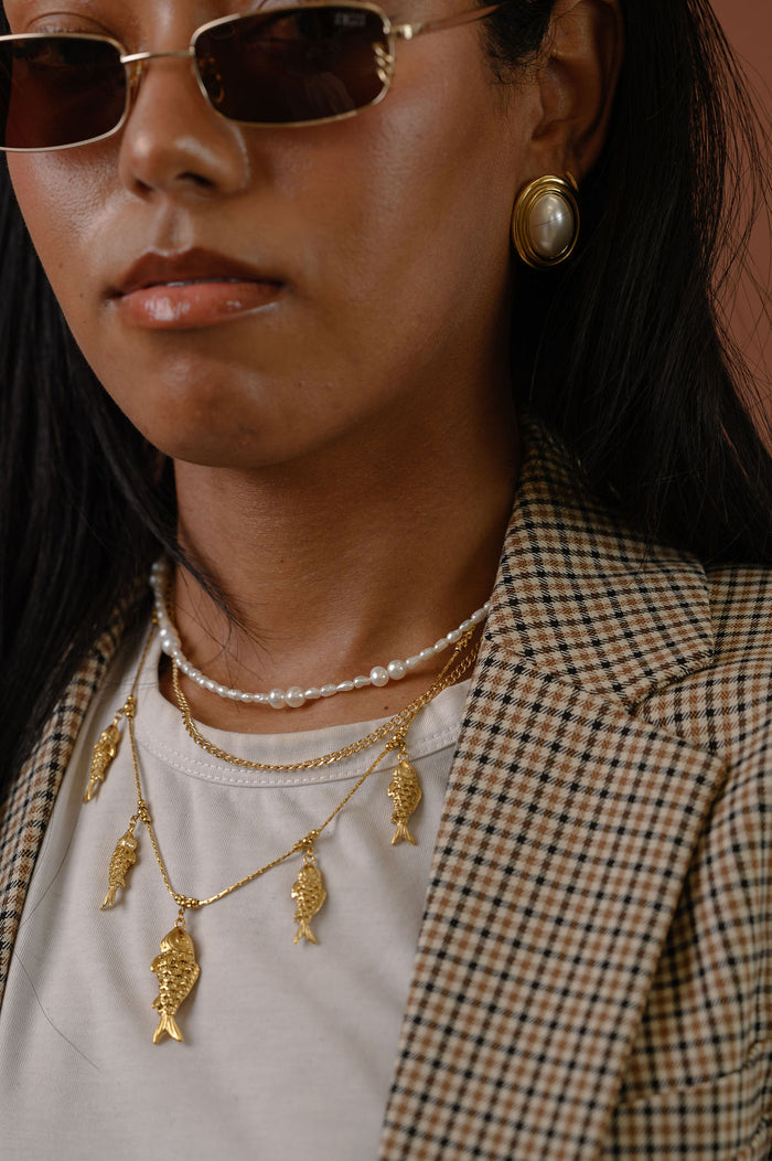 Studio close up of the gold and freshwater pearl Isla necklace on a white background