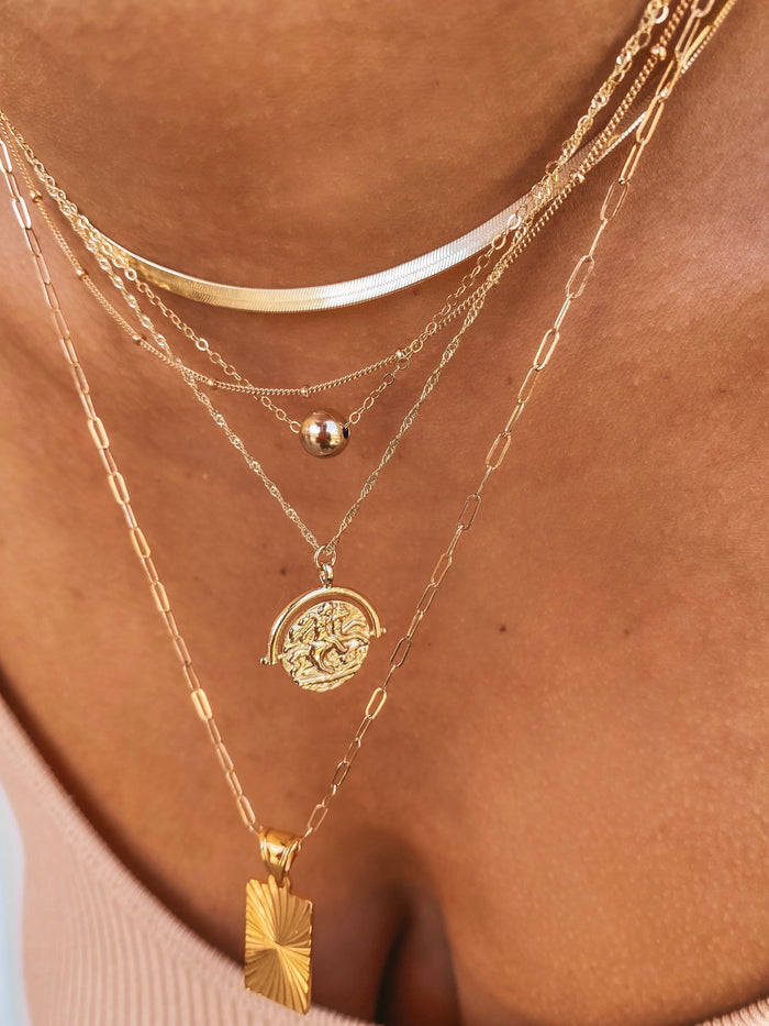 Close up of a neckline wearing the gold Jackie bead necklace