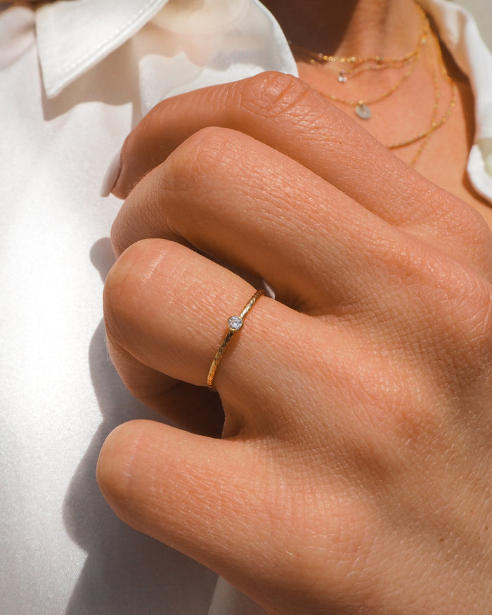 The gold-filled Jessi ring, a textured hammered band with a tiny stone
