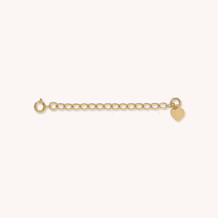 Close up of a gold jewelry extender on a white background