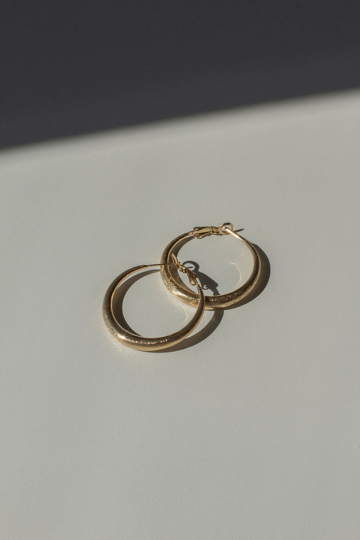 A pair of gold hoops on a white background