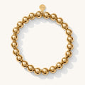 Close up of a gold bead bracelet on a white background