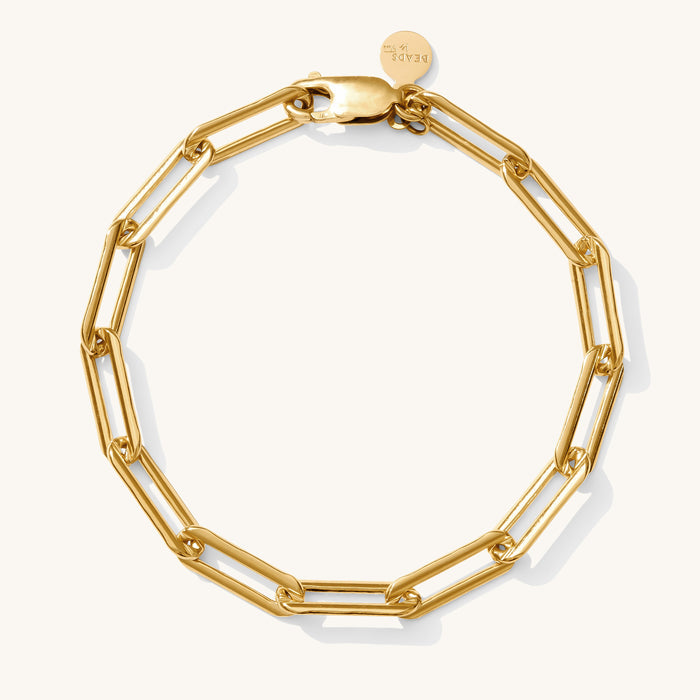 Close up of an oversized gold link bracelet on a white background