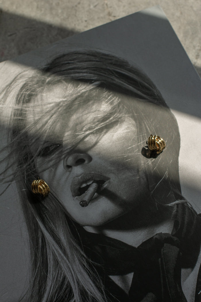 Gold earrings on a black and white photo of a woman