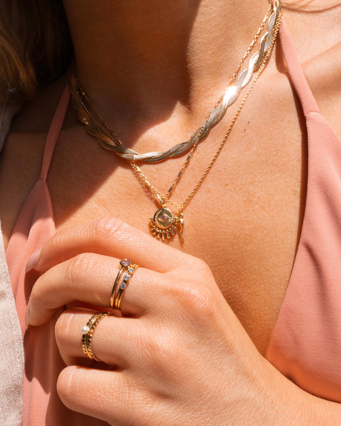Gold-filled Laguna ring styled with layered dainty necklaces and evil eye pieces