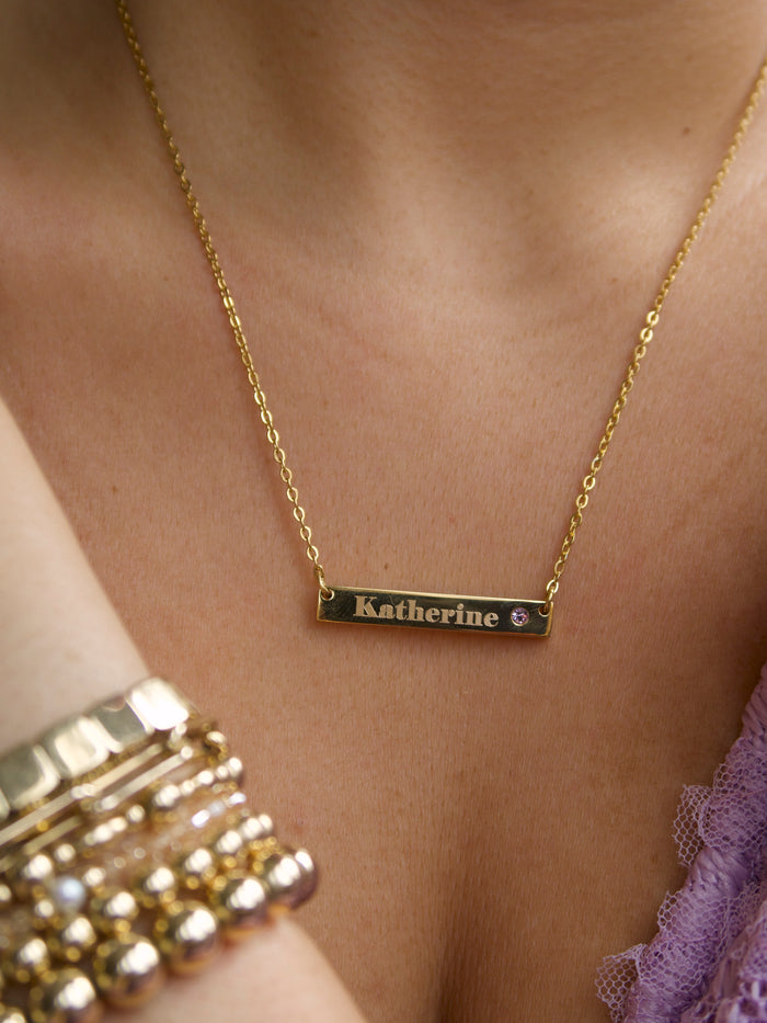 Lennon Birthstone necklace engraved with a name beside a birthstone crystal