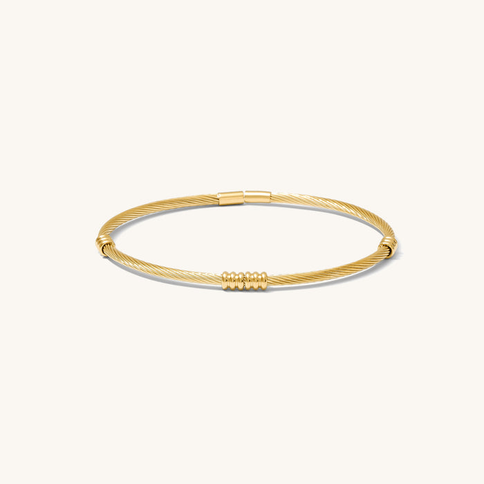 Close up of gold cuff bracelet on a white background