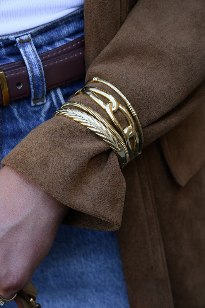 A brown coat sleeve with gold bangles