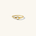 The Lina ring, a thin signet band with a bezel-set clear topaz stone
