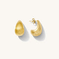 Close up of gold drop earrings on a white background