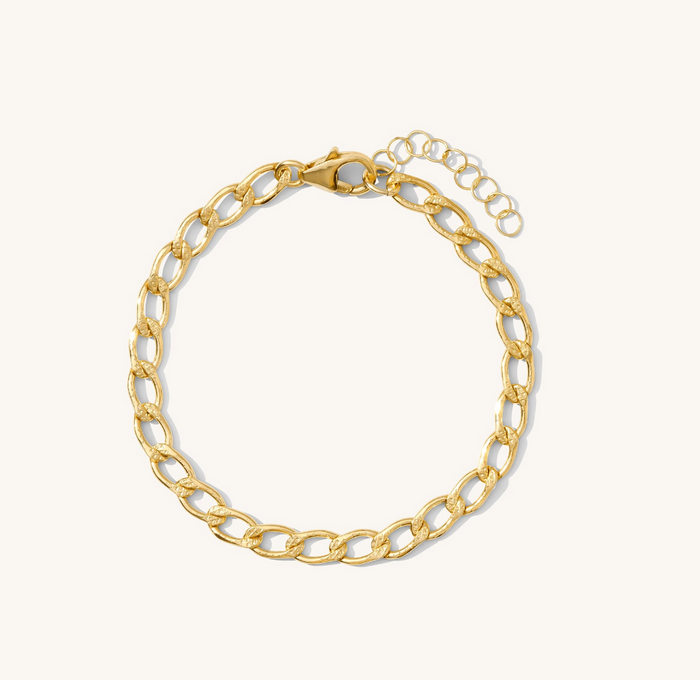 Close up of a gold bracelet on a white backgound