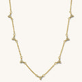Close up of the gold Lotus cluster necklace on a white background