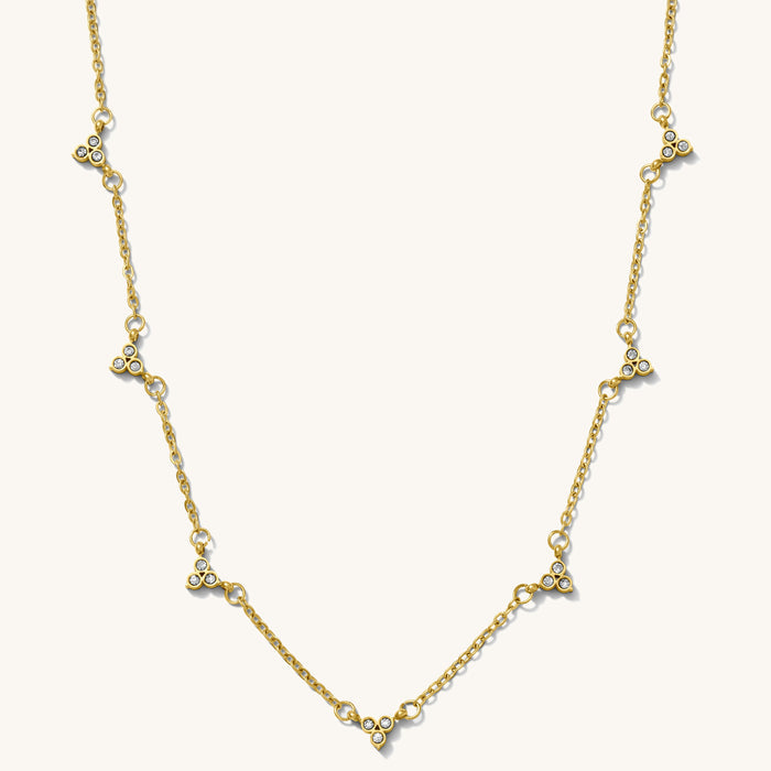Close up of the gold Lotus cluster necklace on a white background