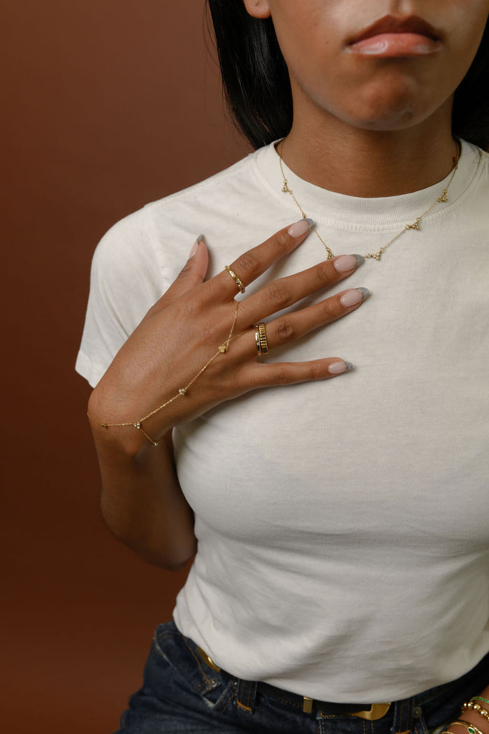 The gold Lotus cluster necklace from Beads by Tara, shown on a white background