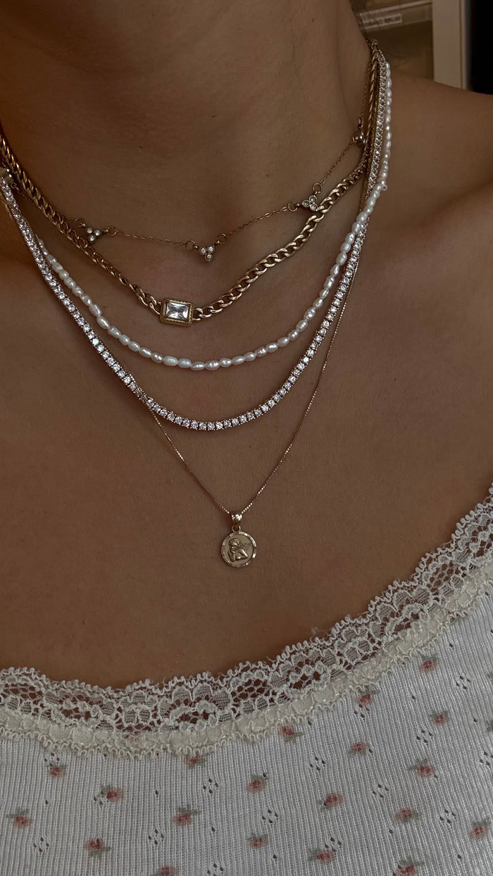 Close view of the 14k solid gold cherub pendant and its carved detail