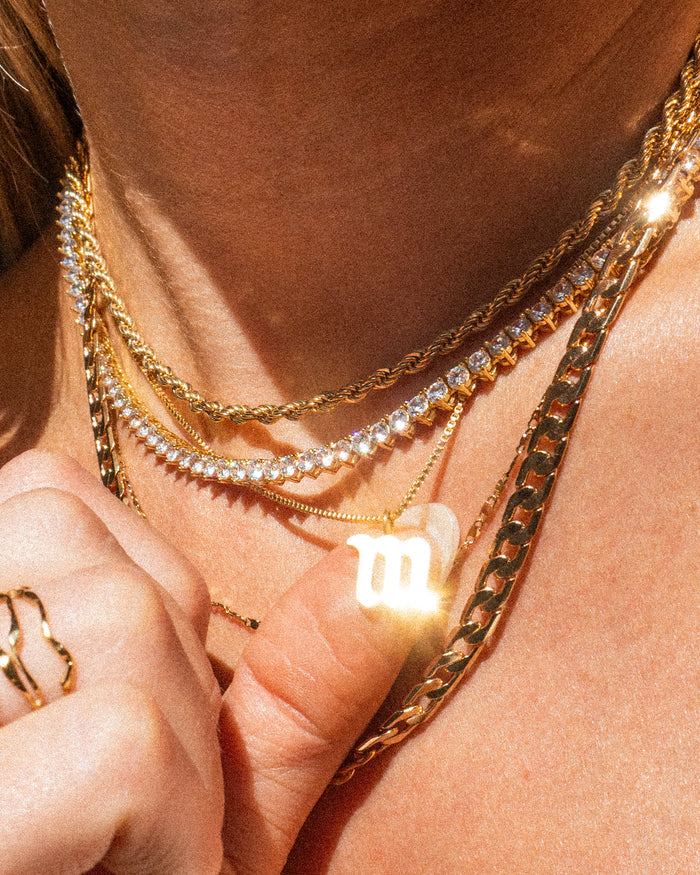 Model wearing the gold Love Letters Old English initial necklace