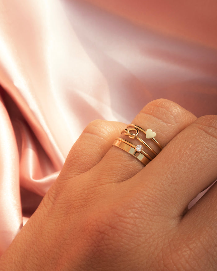 Close up of a hand wearing the Love Me Knot ring in 14k gold fill