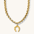 Close up of the gold Lucky Me horseshoe necklace on a white background
