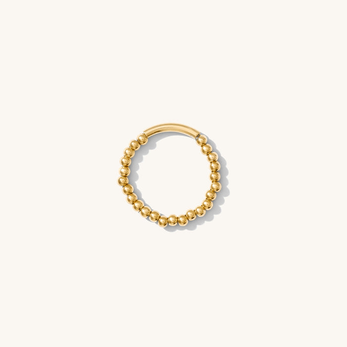 Close up of the gold beaded Luma stacking ring on a white background
