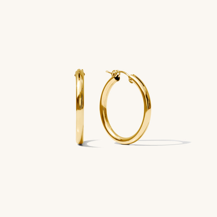 Close up of gold hoop earrings on a white background