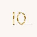 Close up of gold hoop earrings on a white background