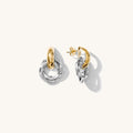 Close up of mixed metal knocker earrings on a white background