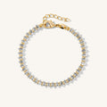 Close up of a gold tennis bracelet with marquise stones on a white background