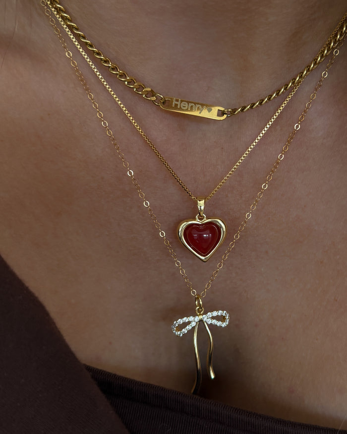 Campaign shot of a model wearing the gold Marlowe bow necklace