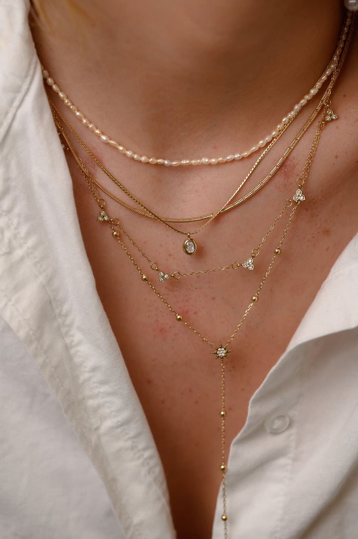 The gold Martina herringbone necklace from Beads by Tara, shown on a white background