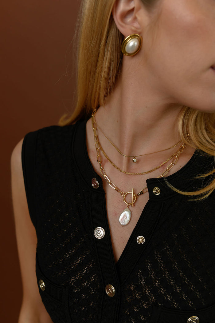 The gold Martina herringbone necklace photographed on a white background