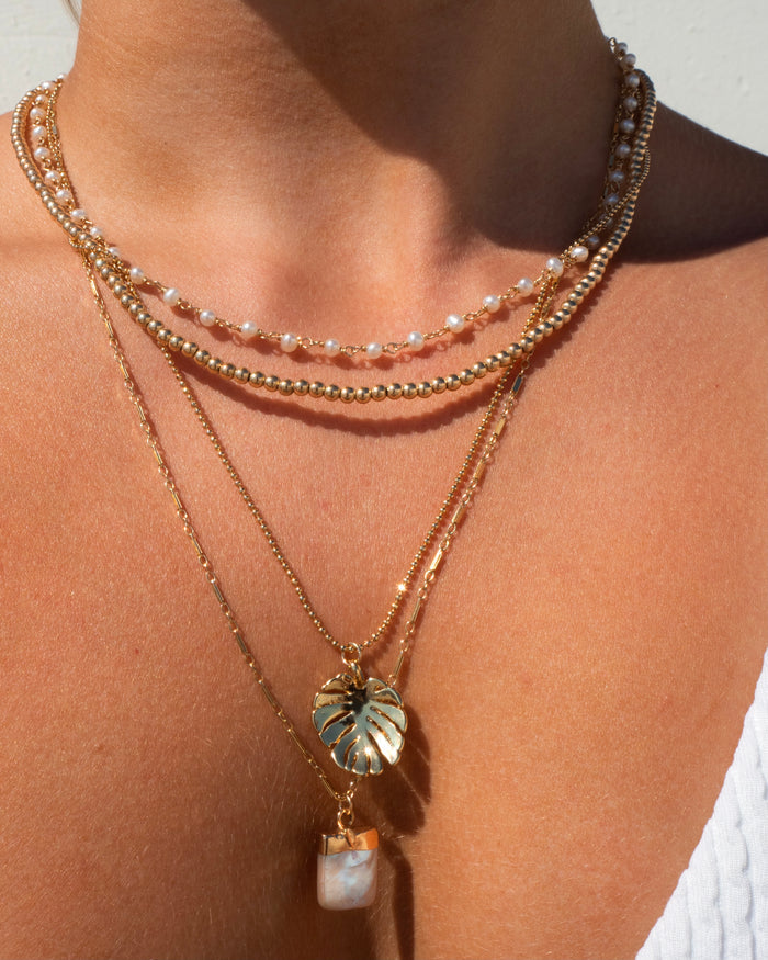 Gold-filled Maui pearl necklace layered with a monstera leaf pendant