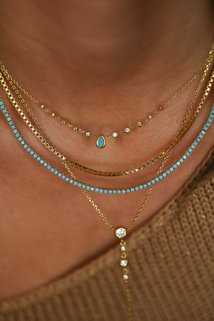 turquoise necklace on model with turquoise tennis necklace