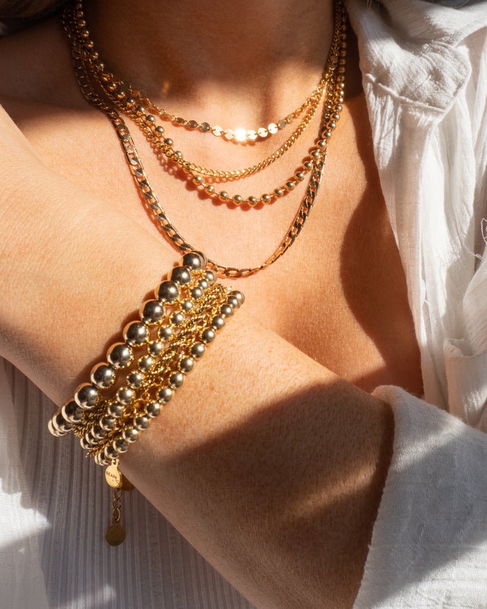 Model wearing the Michelle choker styled with layered gold necklaces