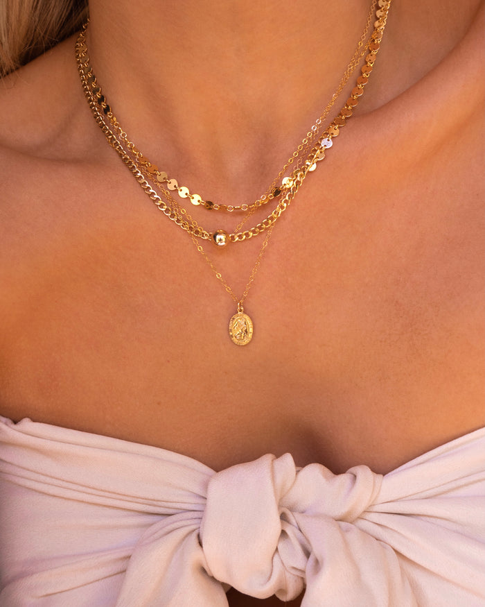 Michelle disc necklace worn layered with other dainty gold chains