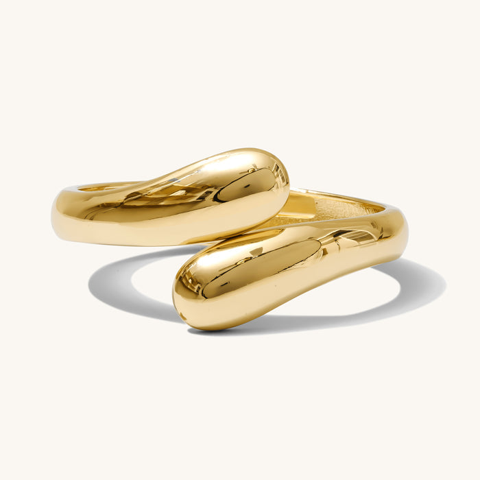 Close up of gold cuff bracelet on a white background