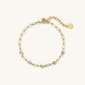 Gold chain bracelet with stones on a white background