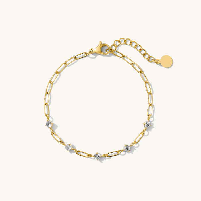Gold chain bracelet with stones on a white background
