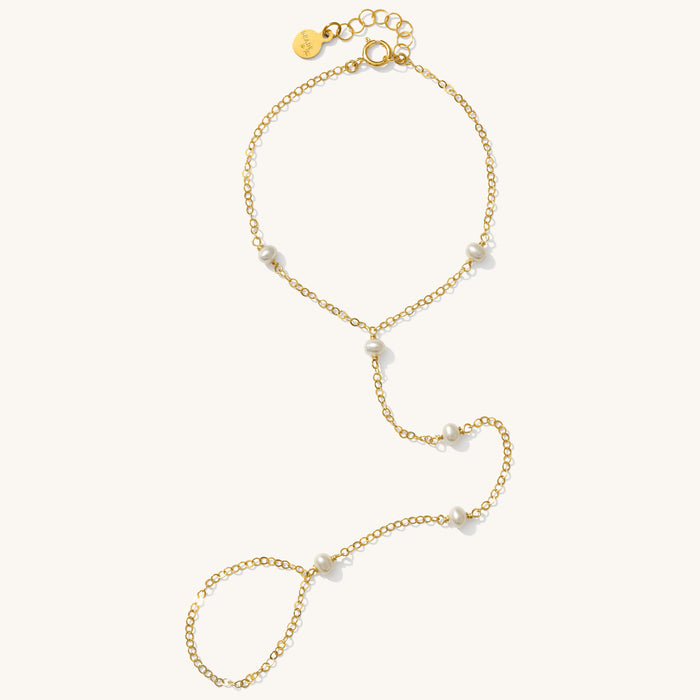 Close up of a hand chain with pearl accents on a white background