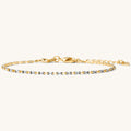Close up of a gold bracelet with stones on a white background