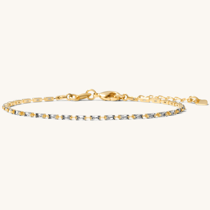 Close up of a gold bracelet with stones on a white background